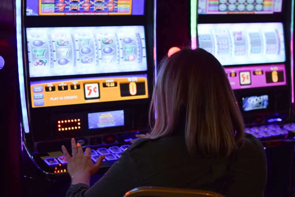 Slot gépeknél játszó ember, mobil kaszinó és asztali élmény összehasonlítása
